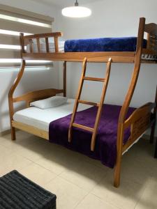 Cette chambre comprend des lits superposés et une chaise. dans l'établissement Departamento en Torre Oceanica, à Salinas