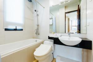 a white bathroom with a toilet and a sink at HB Serviced Apartment - 12 Trần Quý Kiên in Hanoi