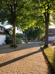 a cobblestone street with trees on either side at Ferienwohnung Am Holzfeld in Schneverdingen