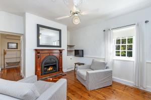 a living room with a couch and a fireplace at Pea Soup Cottage in Port Fairy