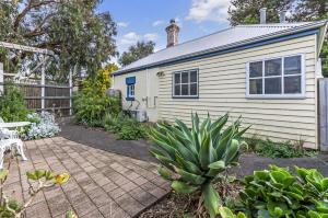a backyard with a house and a patio at Pea Soup Cottage in Port Fairy