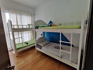 two bunk beds in a room with wooden floors at StarsBed KLCC Skyview Roof Pool Hostel in Kuala Lumpur