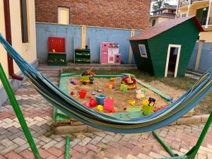 a hammock with toys in the sand in a backyard at Royal Cottage in Ureki