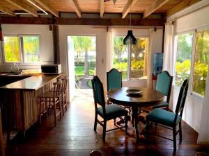 una cucina con tavolo e sedie in legno e bancone di Cabo tortuga bungalows a Monterrico