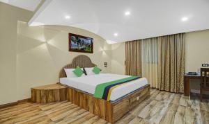 a bedroom with a bed and a desk in it at Treebo Trend Majestic Palms 2 Km From Colva Beach in Benaulim