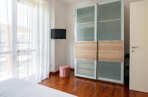 - une chambre avec un lit et un grand placard en verre dans l'établissement Casti - Appartamento MM3 Comasina, à Milan