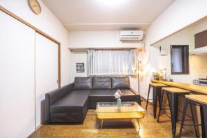 salon z kanapą i stołem w obiekcie nestay apartment tokyo akihabara 2A w Tokio