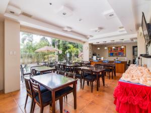 a restaurant with tables and chairs and a large window at Main Hotel & Suites in Cebu City