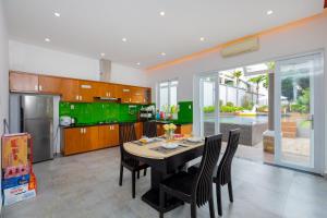 a kitchen with a table and chairs and green cabinets at Palm Villa 39 - Luxury Free Bida & Karaoke in Vung Tau