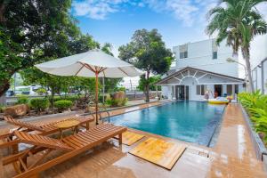 a pool with chairs and an umbrella next to a building at Palm Villa 39 - Luxury Free Bida & Karaoke in Vung Tau