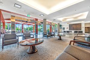 a lobby with chairs and tables in a building at King Studio Harbourfront Haven with Tropical Pool in Darwin