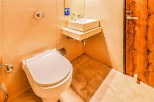 a bathroom with a white toilet and a sink at Hotel Byaris International By Bizzgrow Hotels in Mumbai
