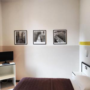 a bedroom with four pictures on the wall at Hotel Italia in Porretta Terme