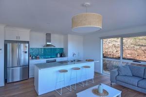 a kitchen with a sink and a counter top at Sandbar Beach House in Coles Bay