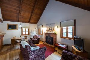 sala de estar con sofá y chimenea en Tanunda Cottages, en Tanunda