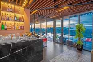 a bar in a restaurant with a view of the city at Pavilion Hotel Da Nang in Da Nang