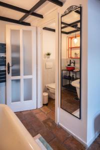 a bathroom with a mirror and a toilet and a tub at MOOKI Rumbach Budapest Apartment in Budapest +111 photos