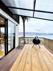 a grill on a wooden deck with a view of the ocean at Lakeview Unit in Queenstown