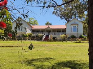 a house with a grass field in front of it at Rosebank Guesthouse in Healesville