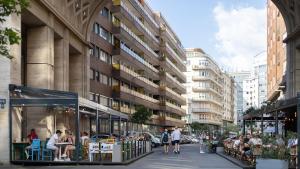 a city street with people sitting outside a building at MOOKI Rumbach Budapest Apartment in Budapest