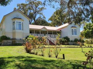 una casa en un césped con árboles y arbustos en Rosebank Guesthouse, en Healesville