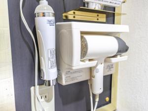 a hair dryer is attached to a wall at Tabist Hotel Please Kobe in Kobe