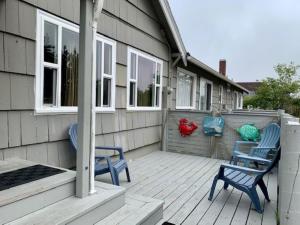 Anchorage Cottages في لونغ بيتش: كرسيان زرقان يجلسان على شرفة منزل