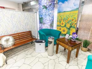 a room with a bench and a table and a mural at Tabist Hotel Please Kobe in Kobe