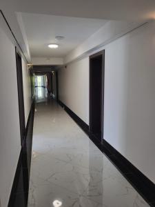 un corridoio con pareti bianche e pavimento piastrellato di Selment Resort a Ełk