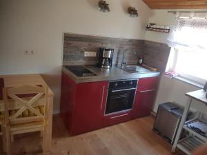 a kitchen with a red stove and a sink at Lamm - Wohnung 4 in Spiegelberg