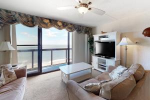 uma sala de estar com um sofá e uma grande janela em Golden Sands 1208 em Ocean City