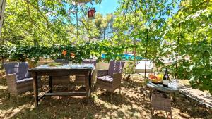 a table and chairs sitting under a tree at Holiday Home Jaga in Biograd na Moru