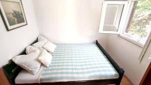 a small bed in a room with a window at Holiday Home Jaga in Biograd na Moru