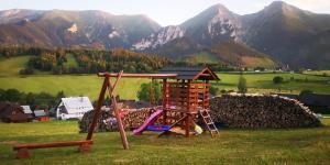 une aire de jeux dans un champ avec des montagnes en arrière-plan dans l'établissement Privát Bachleda Ždiar, à Ždiar