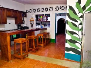 a kitchen with a counter and stools in a room at Hostal El Rio in León