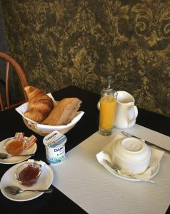 a table with a breakfast of bread and orange juice at Hotel Val De Saone Lyon Caluire Rillieux in Sathonay-Camp