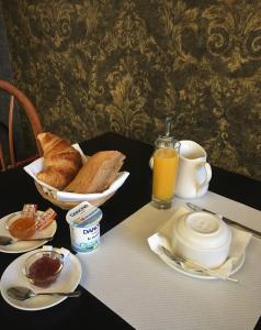 einen Tisch mit einem Frühstück mit Brot und Orangensaft in der Unterkunft Hotel Val De Saone Lyon Caluire Rillieux in Sathonay-Camp