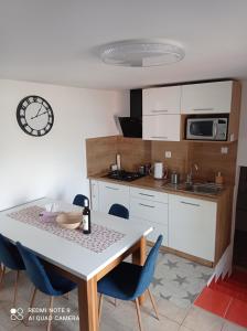 eine Küche mit einem Tisch und blauen Stühlen in einem Zimmer in der Unterkunft Apartman JulRich in Vrbov