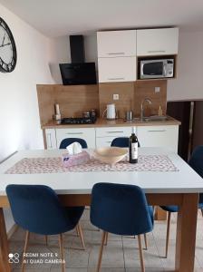 a kitchen with a table with chairs and a bottle of wine at Apartman JulRich in Vrbov