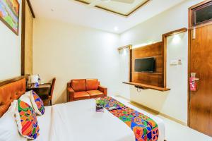 um quarto de hotel com uma cama e uma cadeira em FabHotel Empire Suite em Mumbai