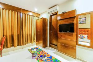 FabHotel Empire Suite في مومباي: غرفة معيشة مع تلفزيون بشاشة مسطحة ومحطة تلفزيون
