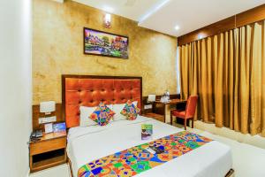 FabHotel Empire Suite في مومباي: فندق غرفه بسرير ومكتب وسرير