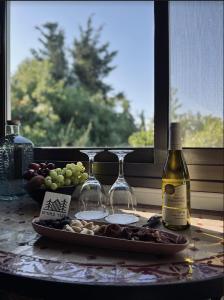 een bord druiven en wijnglazen op een tafel bij Live in the woods in Mikhmannim