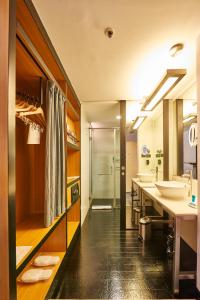 a bathroom with two sinks and a large mirror at Hotel Halez in Chennai