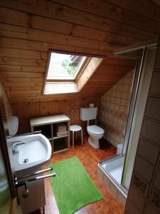 ein Bad mit einem WC, einem Waschbecken und einem Fenster in der Unterkunft Ferienwohnungen Schnarf in Olang