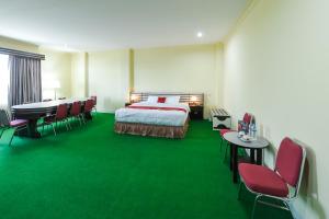 a hotel room with a bed and a table and chairs at RedDoorz at Brother Homestay Kupang in Kupang