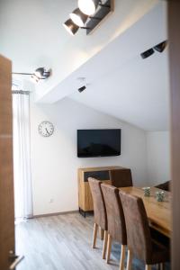 a dining room with a table and chairs and a tv at Ferienwohnung Hoamat in Reutte
