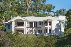 a large white house on a hill with trees at Alexandria Retreat in Doonan