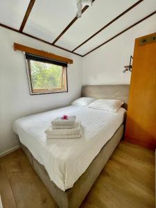 a bedroom with a bed with towels on it at Chalet aan de Rotte in Rotterdam