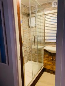 uma casa de banho com uma cabina de duche em vidro e um lavatório. em 30 Granada em Selsey